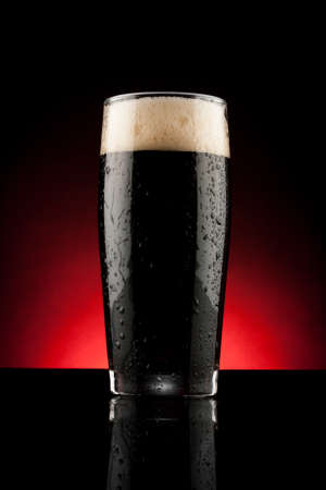glass of black beer with reflection and water dropsの写真素材