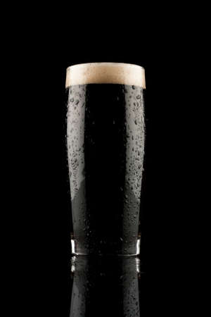 glass of black beer with reflection and water dropsの写真素材