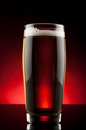 back lit glass of beer with reflectionの写真素材