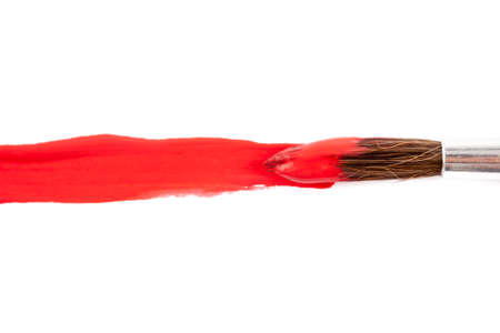 paint brush with red paint on white paperの写真素材