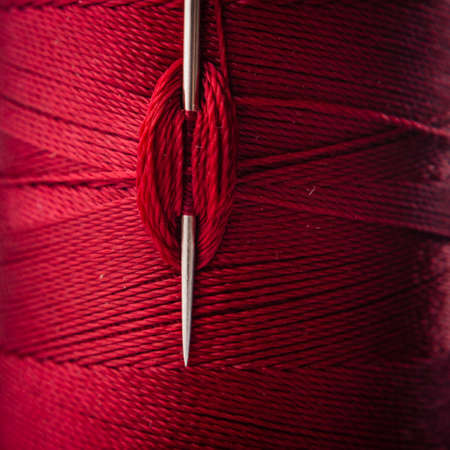 close up of a sewing needle and red threadの写真素材