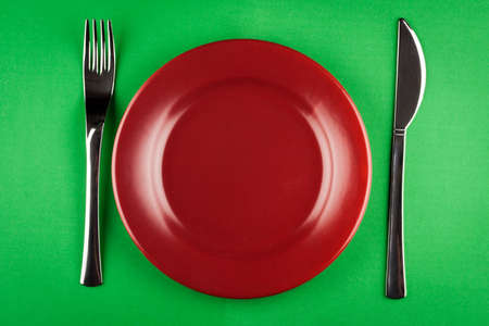 plate with knife and fork on green tableの写真素材