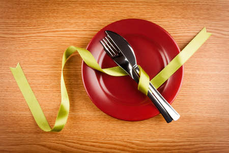 simple table setting with green ribbon and marsala plateの写真素材