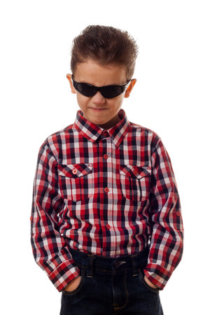 portrait of a boy with sunglasses in checkered shirt and jeans looking angryの写真素材