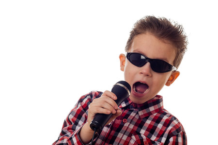 boy in sunglasses and checkered shirt yelling in microphoneの写真素材