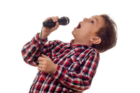 young boy in checkered shirt yelling in microphoneの写真素材