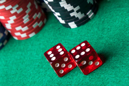 red casino dices and poker chips on green tableの写真素材