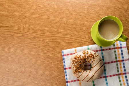 overhead shot of doughnut and coffee in green mug on tableの写真素材