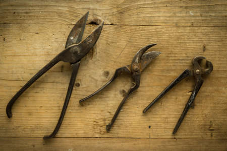 old vintage retro used scissors and pliers on wooden tableの写真素材