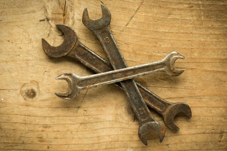old vintage retro used open-end wrenches on wooden tableの写真素材