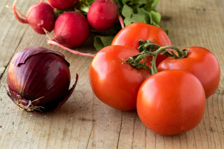 organic onion, tomatoes and radish on wooden tableの写真素材