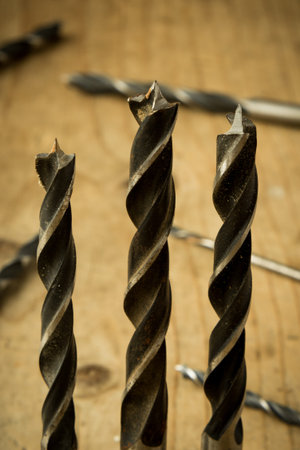 set of used drill bits on wooden table