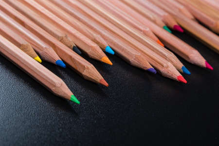 Assortment of colored wood drawing pencils on black tableの写真素材