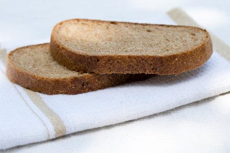 slices of fresh brown bread on table cloth
