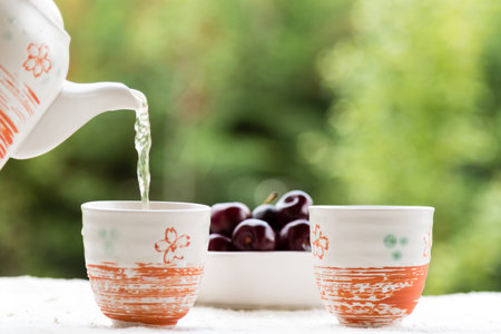fresh healthy hot tea in a teapot and cup whit cherries