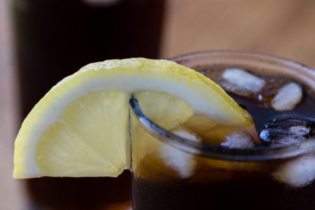 soda glass whit ice cubes and lemon on wooden tableの写真素材