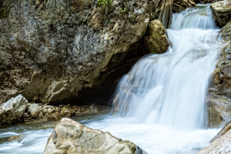 Raging clean fresh mountain river flowing between rocks