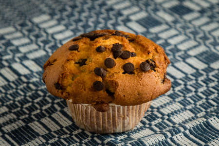 fresh chocolate chip muffin on checkered tableclothの写真素材