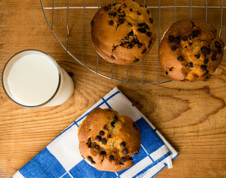 chocolate chip muffins on wooden table with milkの写真素材