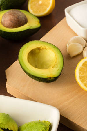 preparing of guacamole with avocado, lemon, onion, and tortilla chipsの写真素材