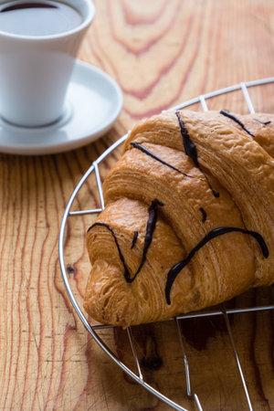 fresh croissant and coffee on a wooden tableの写真素材