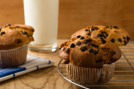 chocolate chip muffins on wooden table with milkの写真素材