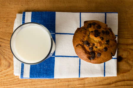 chocolate chip muffin on cloth with milkの写真素材