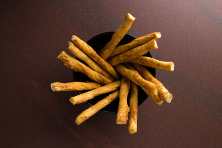 pastry sticks with cheese in a black bowl