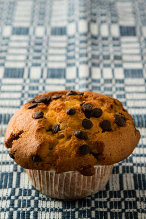 fresh chocolate chip muffin on checkered tableclothの写真素材