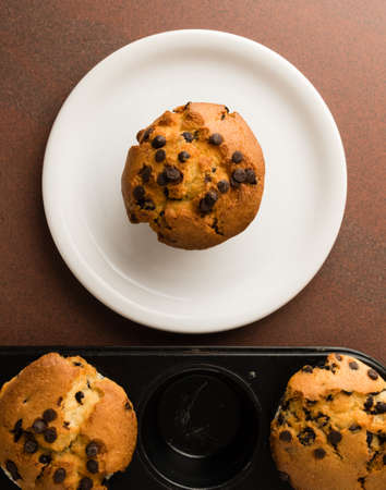 freshly baked chocolate chip muffins in black panの写真素材