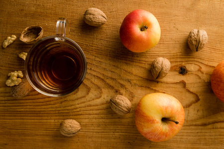 fresh tea with apples and nuts on wooden tableの写真素材