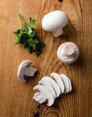 sliced white champignon mushrooms on a wooden tableの写真素材