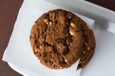 overhead shot of stacked chocolate biscuit cookies with white paperの写真素材