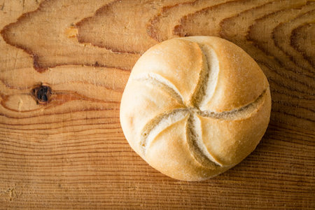 round fresh sandwich bun on wooden tableの写真素材