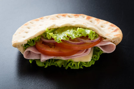 fresh pita ham sandwich on a black tableの写真素材
