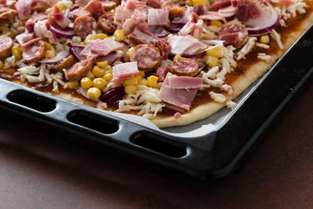 home made pizza in black pan befor bakingの写真素材