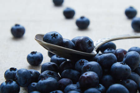 blueberries on table and in a vintage spoonの写真素材