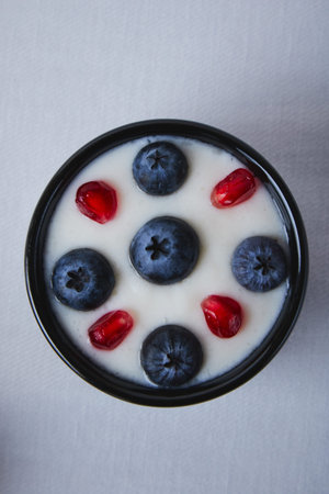 yogurt with blueberry and pomegranate in black bowlの写真素材