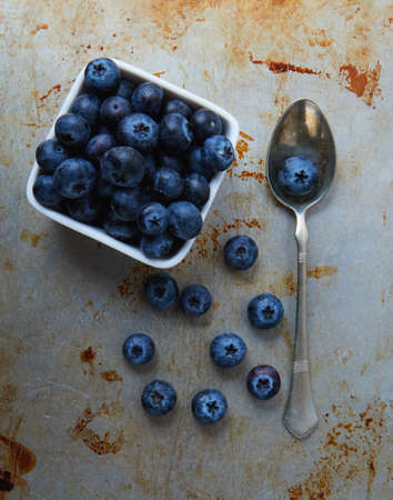 blueberries on steel plate in bowl and spoonの写真素材