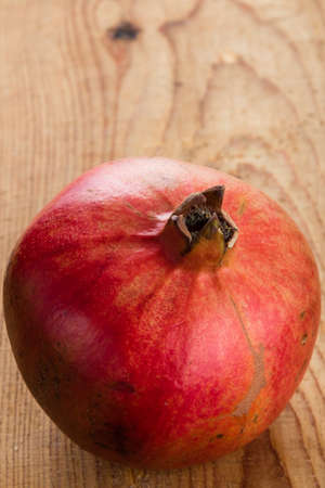 ripe red organic pomegranate on wooden tableの写真素材