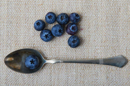 blueberries on table and in a vintage spoonの写真素材