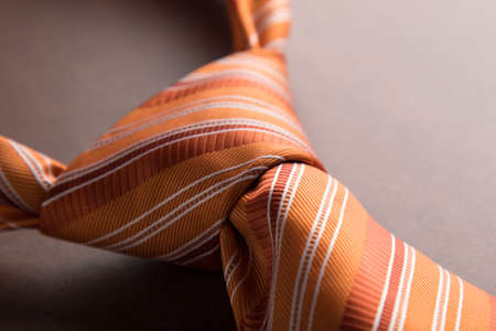 elegant casual orange neck tie knot on tableの写真素材