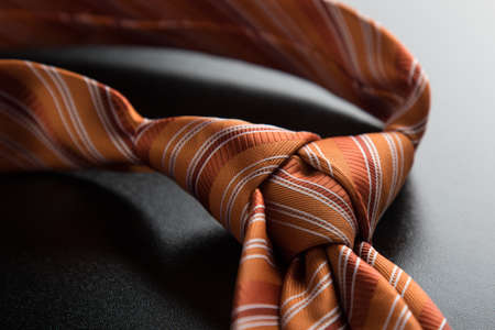 elegant casual orange neck tie knot on black tableの写真素材