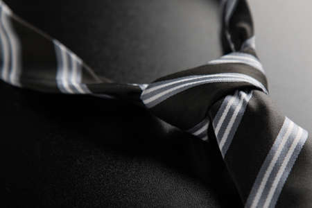 elegant casual neck tie knot with stripes on black tableの写真素材
