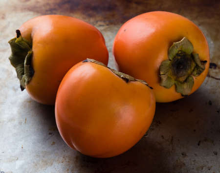 fresh healthy persimmon fruit on steel plateの写真素材