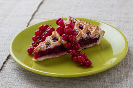 fresh cherry pie on green plate with currant