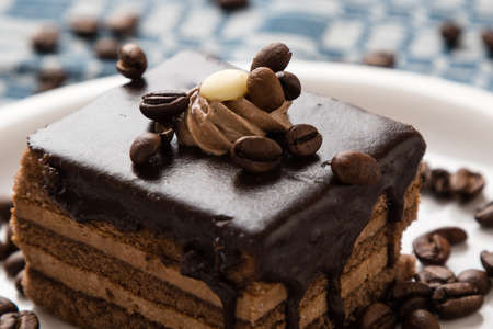 chocolate cake and coffee beans on white plateの写真素材
