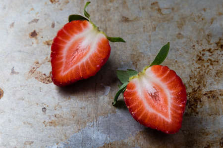 fresh ripe red cut strawberries on steel plateの写真素材