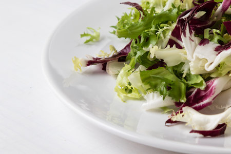 fresh colorful chopped lettuce on white plateの写真素材