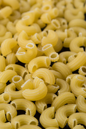 abundance of raw uncooked yellow macaroni closeup